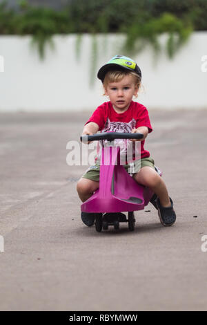 Une photo d'un enfant heureux de la conduite avec un plasma violet voiture comme ride sur toy Banque D'Images