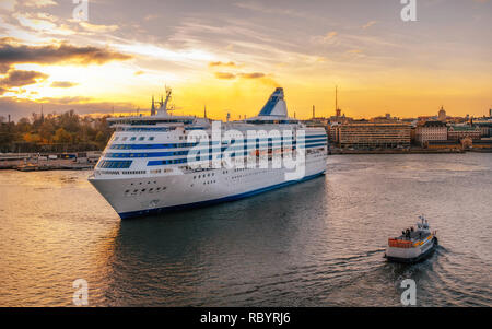 Traversier pour passagers et voile remorqueur contre Helsinki city in South Harbour au coucher du soleil, la Finlande Banque D'Images