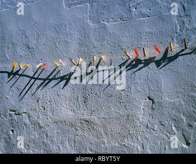 Une corde lave-ligne traversant le centre avec des chevilles en plastique rouge et jaune et de chevilles en bois clipsé sur la ligne a intervalles réguliers, derrière est un Banque D'Images