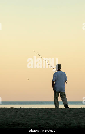 Stock image un pêcheur pêchant à la plage au coucher du soleil sur le lac Ontario. Banque D'Images