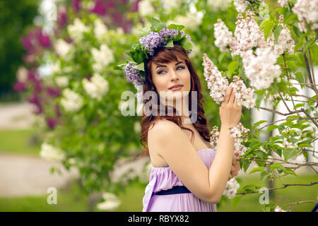 Belle fille en robe violette à fleurs lilas Banque D'Images