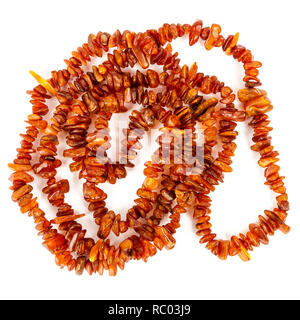 Chaîne de perles d'ambre baltique isolé sur fond blanc. Collier ambre orange vif de matières perles en un tas. Banque D'Images