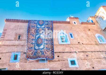 Tapis énorme accroché sur la façade d'un immeuble à Chefchaouen, Maroc Banque D'Images