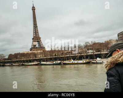 PARIS, FRANCE - Jan 30, 2018 : senior man parisien regarder la Seine près de la Tour Eiffel comme le dépassement de la rivière remblais après des jours de forte pluie Banque D'Images