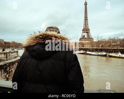 PARIS, FRANCE - Jan 30, 2018 : senior man parisien regarder la Seine près de la Tour Eiffel comme le dépassement de la rivière remblais après des jours de forte pluie Banque D'Images