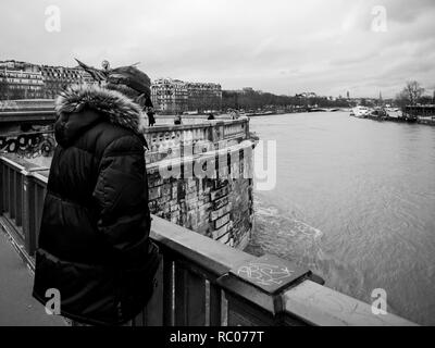 PARIS, FRANCE - Jan 30, 2018 : senior man parisien regarder la Seine près de la Tour Eiffel comme le dépassement de la rivière remblais après des jours de forte pluie Banque D'Images