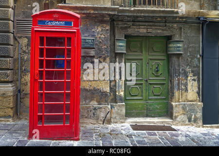 Une cabine téléphonique rouge britannique classique dans une rue de Malte. Banque D'Images