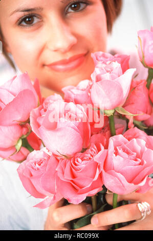 Jeune femme est titulaire d'un bouquet de roses roses, USA Banque D'Images