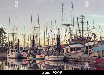 Dans une rue calme soirée d'été, bateaux de pêche commerciale et leurs équipages sont au repos, à Fisherman's Wharf à Port Hardy sur l'île de Vancouver. Banque D'Images