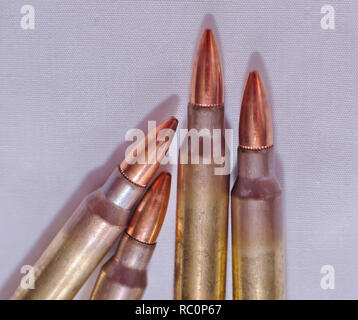 Quatre balles de fusil de calibre 0,223 sur un fond blanc Banque D'Images