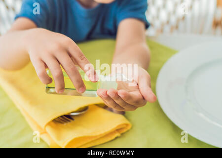 Garçon en utilisant un désinfectant pour les mains de lavage gel dans les cafe. Banque D'Images