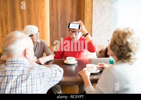 Les Aînés jouant mot-jeu d'estimation in cafe Banque D'Images