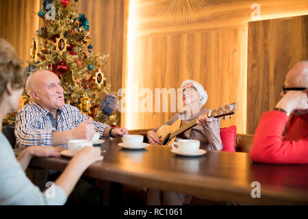 Vieille dame chanter chanson avec des amis Banque D'Images