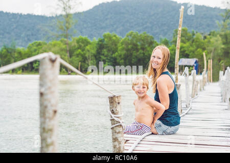Mère et fils sont assis sur le vieux quai et profiter de la mer. Banque D'Images