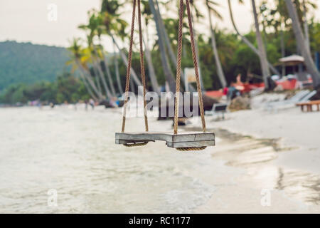 L'été, les voyages, vacances et Maison de Vacances - Swing concept pendre du cocotier plage mer arbre de plus. Banque D'Images