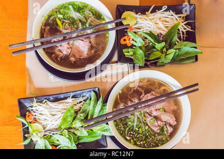 Pho Bo - soupe de nouilles de riz fraîches vietnamienne au boeuf, les herbes et le piment. Plat national du Vietnam. Banque D'Images