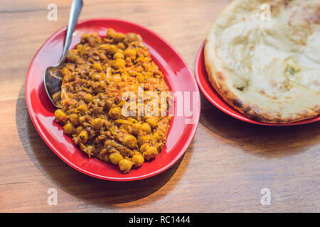 La nourriture indienne ou indien curry dans un bol de service cuivre laiton avec nan pain ou roti Banque D'Images