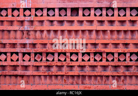 Macro photo d'un mur de briques d'ornement rouge avec différents motifs géométriques. Banque D'Images