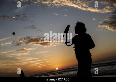 Gaza, la Palestine. Jan 12, 2019. Un Palestinien vu jouer au tennis au coucher du soleil sur la plage de la mer de la ville de Gaza. Credit : Mohamed Zarandah SOPA/Images/ZUMA/Alamy Fil Live News Banque D'Images