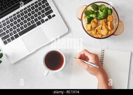 Travailler avec une pause-café dans la journée. Avec déjeuner garni de riz sauté de poulet et brocoli, café. Avec mon ordinateur portable préféré. Banque D'Images
