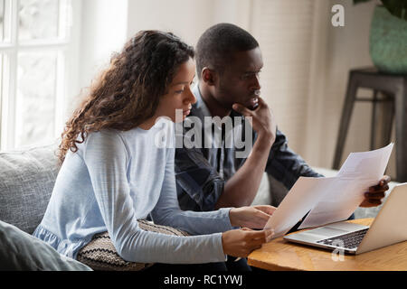African American couple inquiète sérieusement la lecture de documents à l'hom Banque D'Images