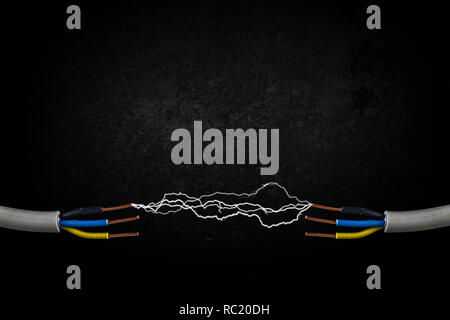 Deux câbles électriques avec sparkles. La foudre l'électricité rougeoyant. Pierre sombre arrière-plan avec copie espace. Banque D'Images