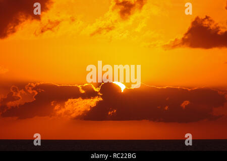 Vue sur le magnifique coucher de soleil avec des nuages au-dessus de paysage au coucher de soleil. Les rayons du soleil en passant par les nuages. Banque D'Images