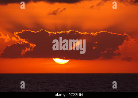 Vue sur le magnifique coucher de soleil avec des nuages au-dessus de paysage au coucher de soleil. Les rayons du soleil en passant par les nuages. Banque D'Images