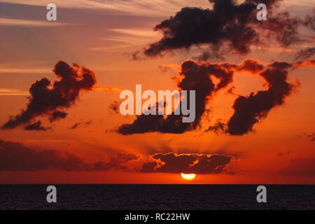 Vue sur le magnifique coucher de soleil avec des nuages au-dessus de paysage au coucher de soleil. Les rayons du soleil en passant par les nuages. Banque D'Images