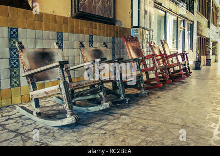 Vue sur le sol en bois vintage / retro chaises à bascule dans l'allée. Banque D'Images