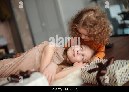 Deux jolies soeurs de vous détendre dans le salon la veille de Noël. Banque D'Images