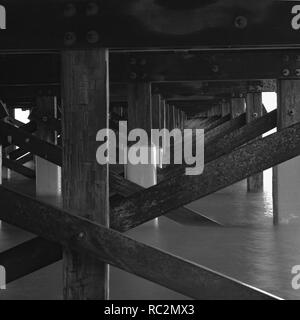 Une longue exposition en noir et blanc tourné sous un vieux pont en bois, Banque D'Images