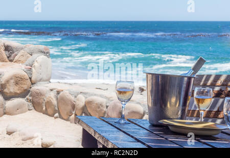 Verres à vin rustique à une table de restaurant de plage face à l'océan Atlantique - Image Banque D'Images