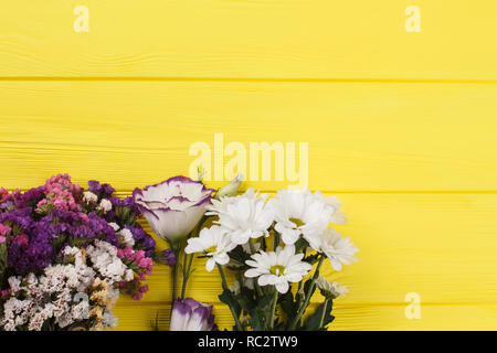 Bouquets de fleurs différentes sur bois jaune. Close up. Vue d'en haut. Banque D'Images