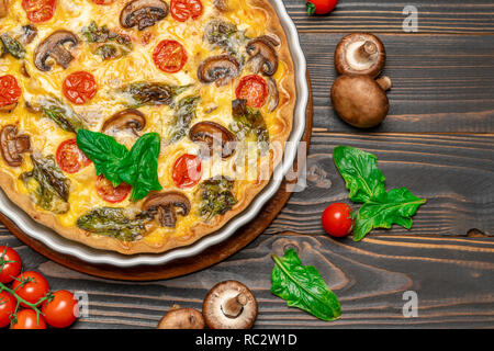 Maison cuites quiche tarte en forme de cuisson en céramique sur fond de béton Banque D'Images