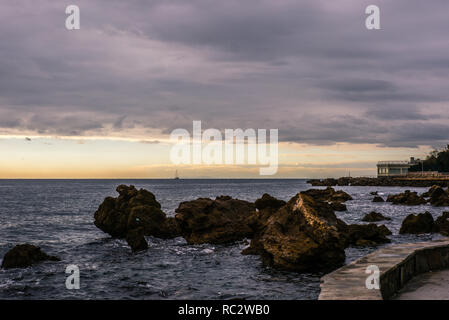 La promenade de Castiglioncello en Toscane en hiver au coucher du soleil avec une île et un bateau à voile à l'horizon - 3 Banque D'Images