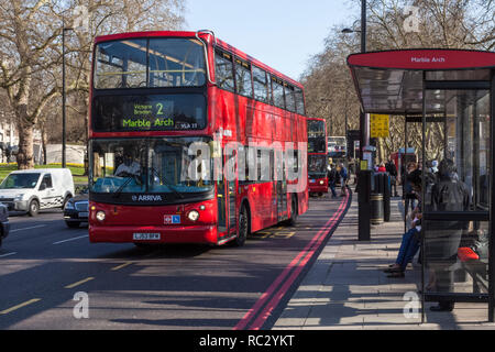 Un double decker bus Londres arriva, en tirant d'un arrêt de bus sur une route très fréquentée, Marble Arch, London, England, UK Banque D'Images