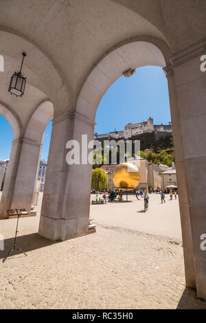 Salzbourg, Autriche - 13 Avril 2018 : vue sur Kapitelplatz, château de Hohensalzburg, man on golden globe (sculpture) et par tourusts Sphaera arches Banque D'Images