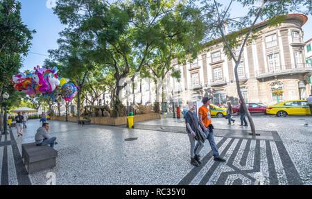 Les gens qui marchent le long de l'avenue bordée d 'Avenida Mariage" à Funchal, Madère pendant la journée. Banque D'Images