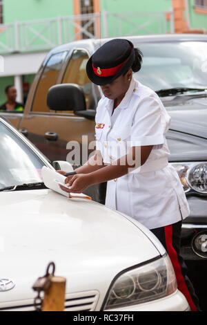 / Nassau Bahamas - Avril 3,2007 : Portrait d'un agent de la police des Bahamas femme vêtue de l'uniforme blanc et noir hat écrit le billet de stationnement. Banque D'Images