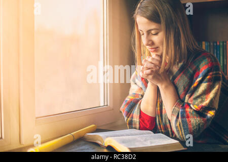 Belle femme priant d'avoir la Bible ouverte devant elle Banque D'Images