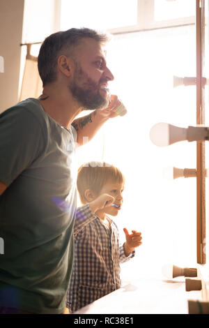 Famille se brosser les dents dans la salle de bains Banque D'Images