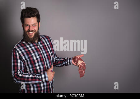 Smiling man holding matières viandes fraîches et showing thumb up concept qualité copie espace pour le texte Banque D'Images