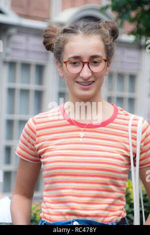 Un portrait of a smiling girl geek à la marche sur une rue Banque D'Images