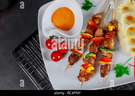 Plat délicieux grillés brochettes de viande mixte servis avec frites légumes et purée de pommes de terre Banque D'Images