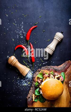Burger Chef avec des morceaux de viande de bœuf, champignons et microgreens. Vue de dessus, copiez l'espace. Banque D'Images