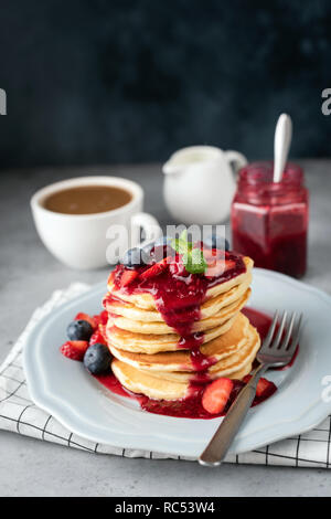 Pile de crêpes avec sauce aux baies sucrées. Délicieux petit déjeuner avec des crêpes, de la confiture et du café Banque D'Images