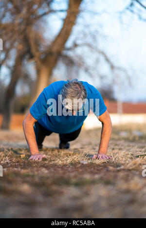 Man faisant pompes sur une piscine d'entraînement Banque D'Images
