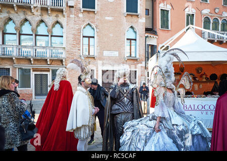 Venise, Italie - Février 10, 2018 : les gens dans l'or des masques et des costumes blanc et argent dans la rue pendant le carnaval Banque D'Images