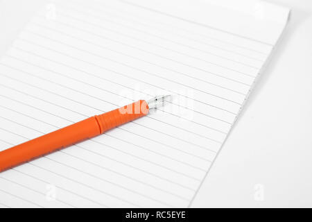 Photo de portable avec stylo. Isolé sur le fond blanc. Banque D'Images